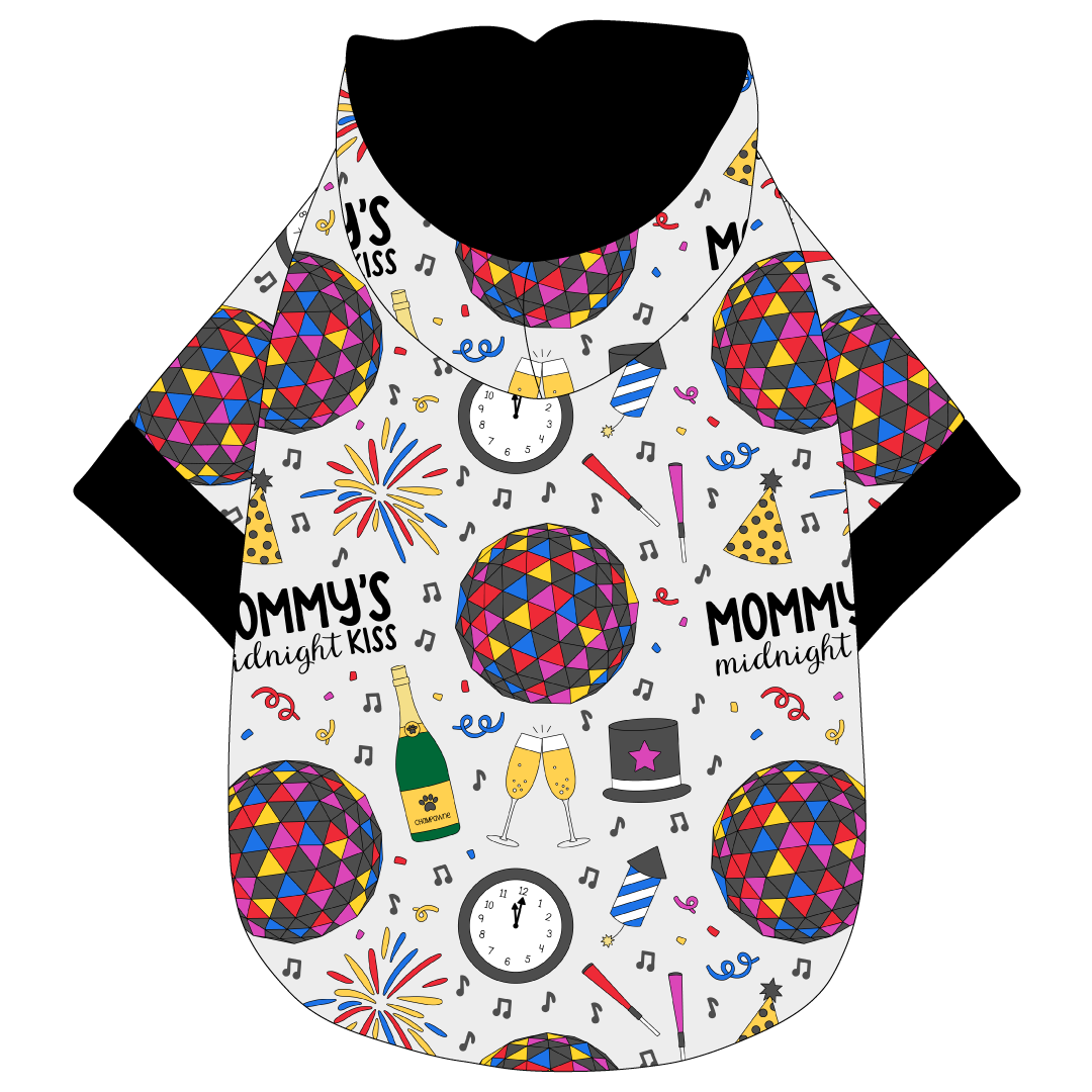 Hoodie in a dog friendly pattern that shows a multi-colored New Years ball, the words Mommy's Midnight Kiss, a clock, champagne bottle and champagne toast, fireworks, confetti and more on a white background. It's complete with a hood lined in black. Black trim is on the waist and sleeves