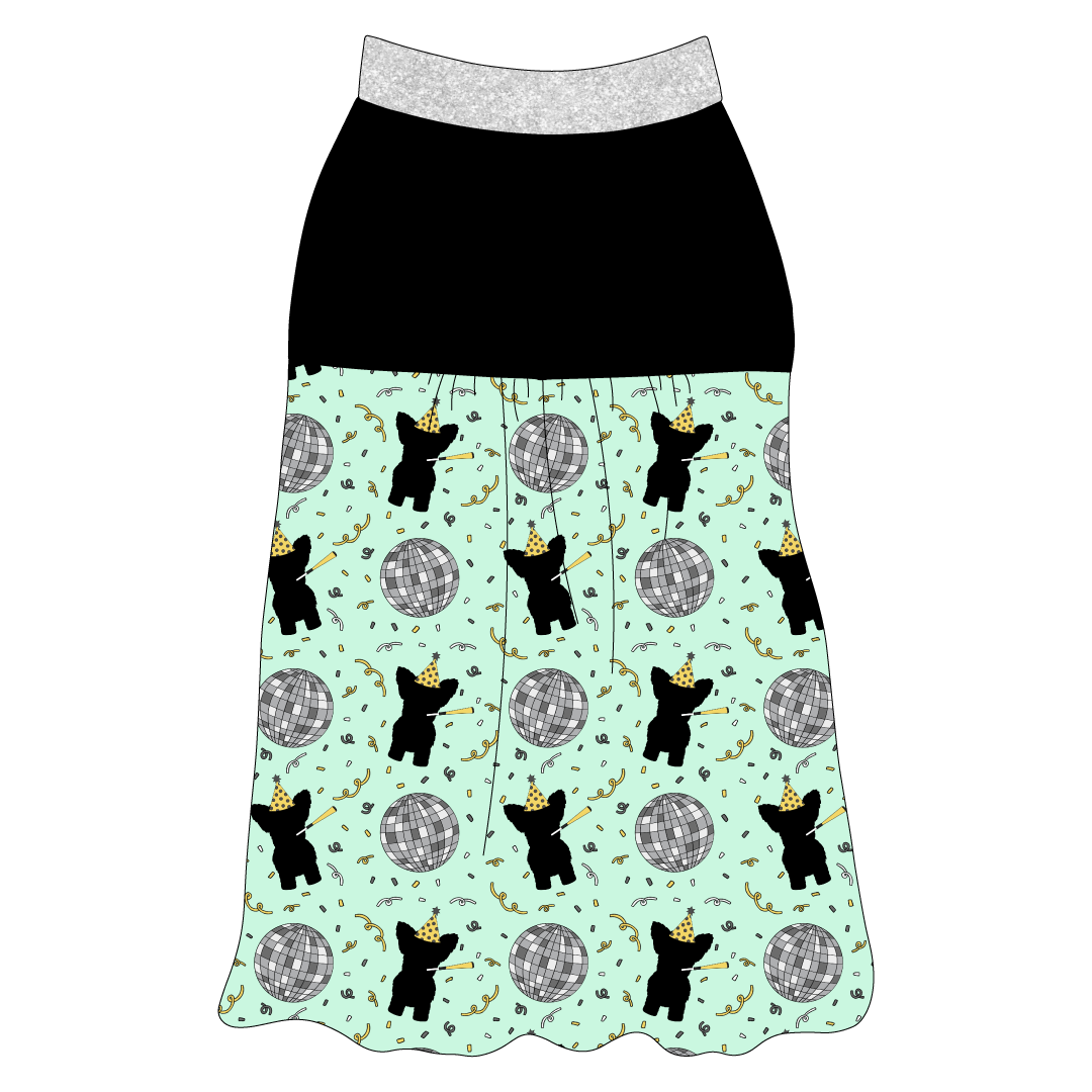 Tank style in a dog friendly pattern that shows a mirror ball, dog with a party blower and confetti on a light green background. It's complete with solid black on the upper back and gathering at the yoke. Silver sparkle trim is on the neck and shoulders.