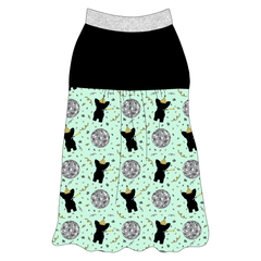 Tank style in a dog friendly pattern that shows a mirror ball, dog with a party blower and confetti on a light green background. It's complete with solid black on the upper back and gathering at the yoke. Silver sparkle trim is on the neck and shoulders.