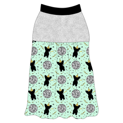 Tank style in a dog friendly pattern that shows a mirror ball, dog with a party blower and confetti on a light green background. It's complete with silver sparkle on the upper back and gathering at the yoke. Black trim is on the neck and shoulders.