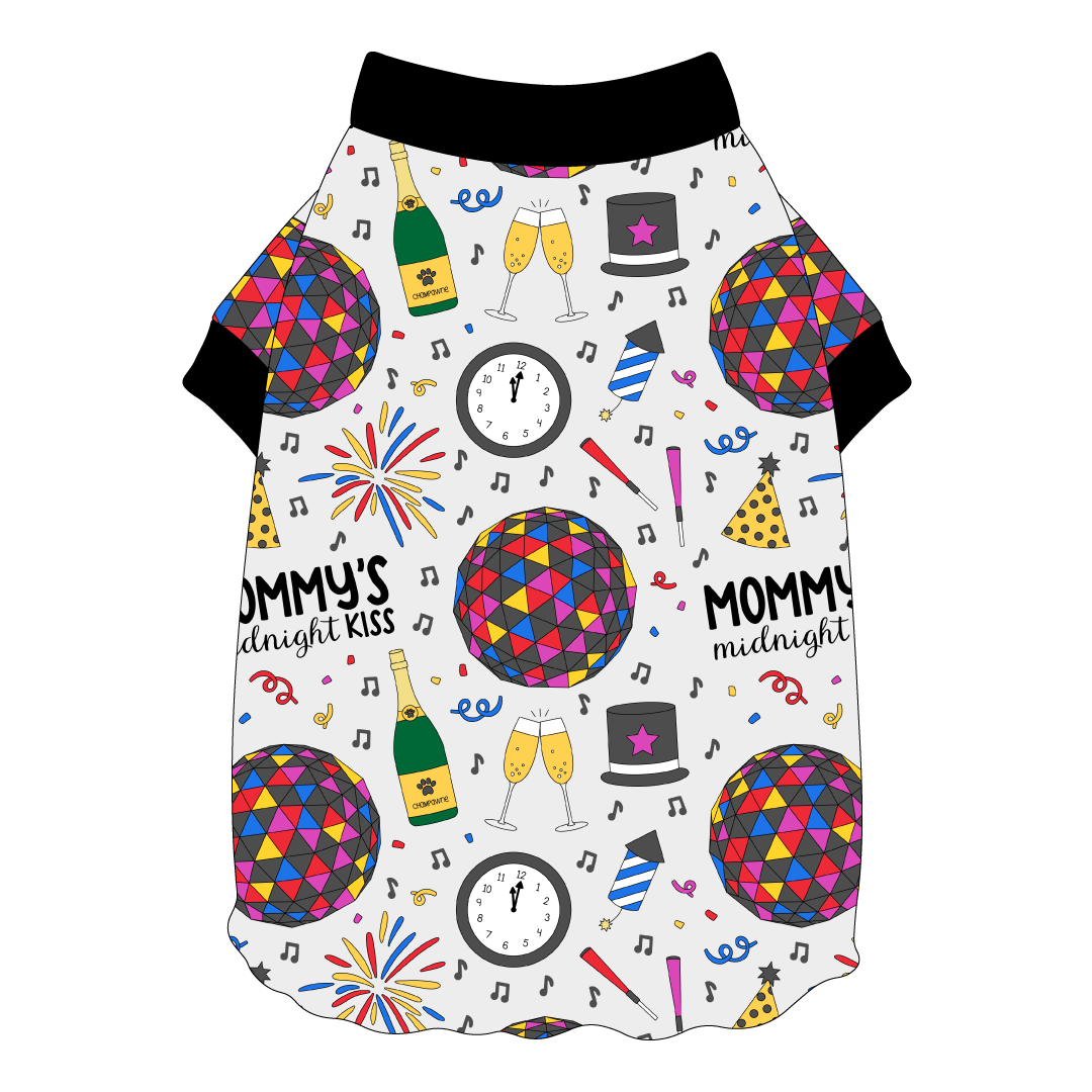 Tee shirt with flutter hem in a dog friendly pattern that shows a multi-colored New Years ball, the words Mommy's Midnight Kiss, a clock, champagne bottle and champagne toast, fireworks, confetti and more on a white background. It's complete with black trim on the neck and sleeves.