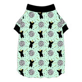 Tee shirt with flutter hem in a dog friendly pattern that shows a mirror ball, dog with a party blower and confetti on a light green background. It's complete with black trim on the neck and sleeves.