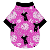 Tee shirt in a dog friendly pattern that shows a girl dog with hat and necklace, along with a mirror ball, champagne glasses, fireworks and confetti on a magenta cheetah print background. It's complete with black trim on the neck, waist and sleeves.