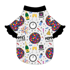 Tee style in a dog friendly pattern that shows a multi-colored New Years ball, the words Mommy's Midnight Kiss, a clock, champagne bottle and champagne toast, fireworks, confetti and more on a white background. It's complete with black ruffles on the sleeve edges. Black trim is also on the neck and waist.