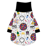 Tee shirt with turtleneck in a dog friendly pattern that shows a multi-colored New Years ball, the words Mommy's Midnight Kiss, a clock, champagne bottle and champagne toast, fireworks, confetti and more on a white background. It's complete with black trim on the neck, waist and sleeves.
