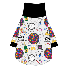 Tee shirt with turtleneck in a dog friendly pattern that shows a multi-colored New Years ball, the words Mommy's Midnight Kiss, a clock, champagne bottle and champagne toast, fireworks, confetti and more on a white background. It's complete with black trim on the neck, waist and sleeves.