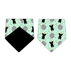 Bandana in a dog friendly pattern that shows a mirror ball, dog with a party blower and confetti on a light green background.  Design is reversible with black on the opposite side.