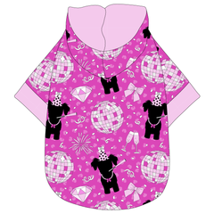 Hoodie in a dog friendly pattern that shows a girl dog with hat and necklace, along with a mirror ball, champagne glasses, fireworks and confetti on a magenta cheetah print background. It's complete with a hood lined in solid light pink. Light pink trim is also on the waist and sleeves.