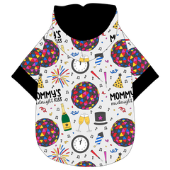 Hoodie in a dog friendly pattern that shows a multi-colored New Years ball, the words Mommy's Midnight Kiss, a clock, champagne bottle and champagne toast, fireworks, confetti and more on a white background.  It's complete with a hood lined in black. Black trim is on the waist and sleeves