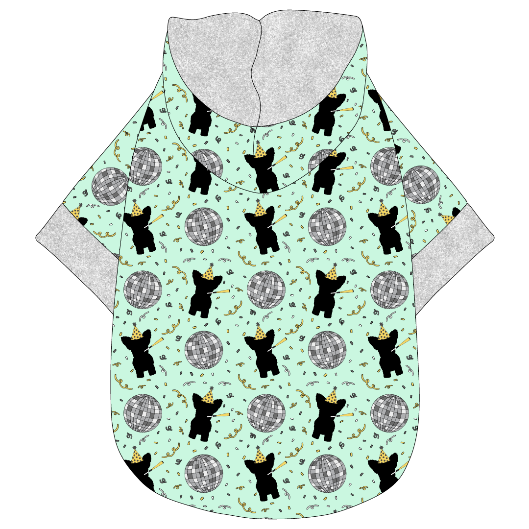 Hoodie in a dog friendly pattern that shows a mirror ball, dog with a party blower and confetti on a light green background.  It's complete with a hood lined in silver sparkle. Silver sparkle trim is on the waist and sleeves