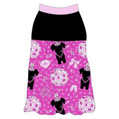 Tank style in a dog friendly pattern that shows a girl dog with hat and necklace, along with a mirror ball, champagne glasses, fireworks and confetti on a magenta cheetah print background. It's complete with solid black on the upper back and gathering at the yoke. Light pink trim is on the neck and shoulders.