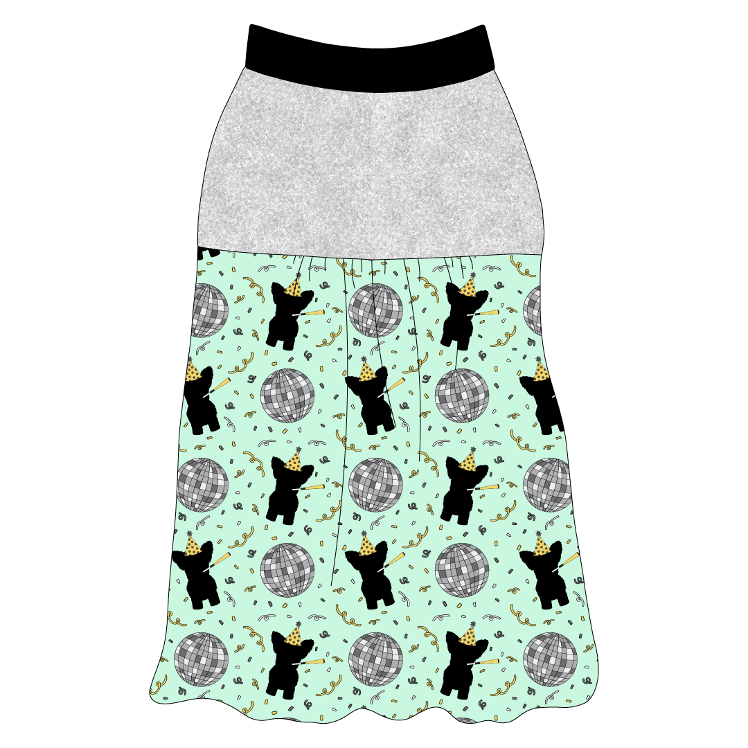 Tank style in a dog friendly pattern that shows a mirror ball, dog with a party blower and confetti on a light green background.  It's complete with silver sparkle on the upper back and gathering at the yoke. Black trim is on the neck and shoulders.