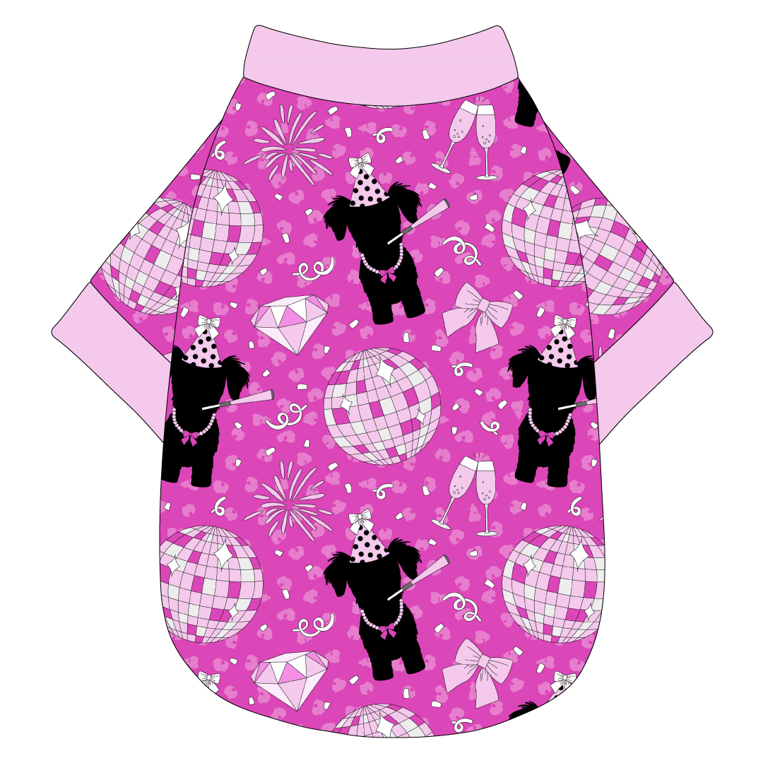 Tee shirt in a dog friendly pattern that shows a girl dog with hat and necklace, along with a mirror ball, champagne glasses, fireworks and confetti on a magenta cheetah print background. It's complete with light pink trim on the neck, waist and sleeves.