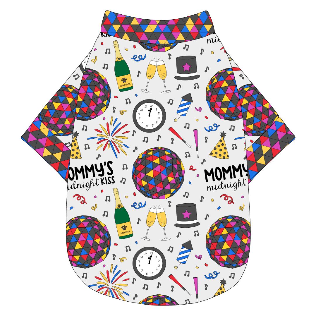 Tee shirt in a dog friendly pattern that shows a multi-colored New Years ball, the words Mommy's Midnight Kiss, a clock, champagne bottle and champagne toast, fireworks, confetti and more on a white background.  It's complete with NYE Ball trim on the neck, waist and sleeves