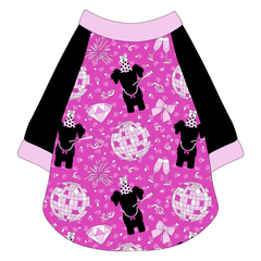 Raglan style tee in a dog friendly pattern that shows a girl dog with hat and necklace, along with a mirror ball, champagne glasses, fireworks and confetti on a magenta cheetah print background. It's complete with solid black sleeves and trimmed in light pink. Light pink trim is also on the neck and waist.