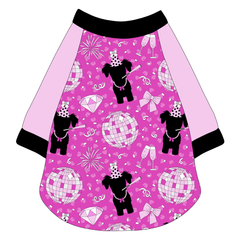 Raglan style tee in a dog friendly pattern that shows a girl dog with hat and necklace, along with a mirror ball, champagne glasses, fireworks and confetti on a magenta cheetah print background. It's complete with solid light pink sleeves and trimmed in black. Black trim is also on the neck and waist.