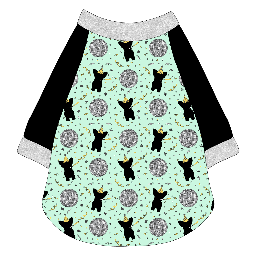 Raglan style tee in a dog friendly pattern that shows a mirror ball, dog with a party blower and confetti on a light green background.  It's complete with black sleeves and trimmed in silver sparkle. Silver sparkle trim is also on the neck and waist.