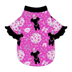 Tee style in a dog friendly pattern that shows a girl dog with hat and necklace, along with a mirror ball, champagne glasses, fireworks and confetti on a magenta cheetah print background. It's complete with black ruffles on the sleeve edges. Black trim is also on the neck and waist.