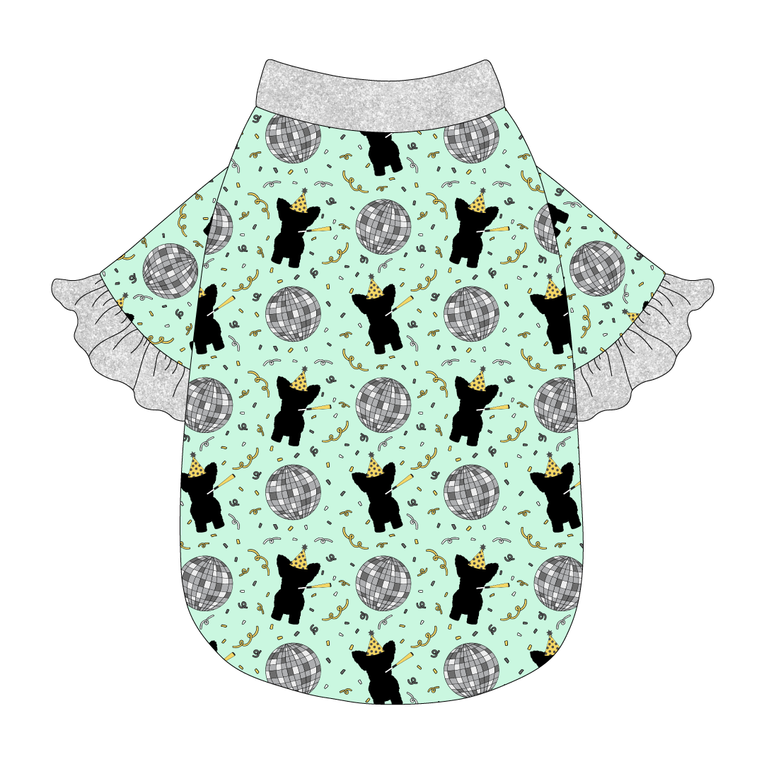 Tee style in a dog friendly pattern that shows a mirror ball, dog with a party blower and confetti on a light green background. It's complete with silver sparkle ruffles on the sleeve edges. Silver sparkle trim is also on the neck and waist.