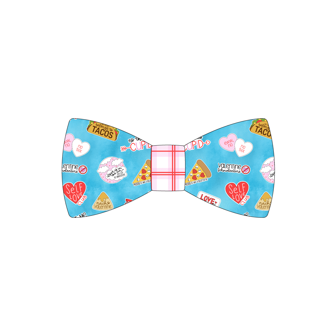 Bowtie in a dog friendly pattern that shows witty anti-Valentine phrases and fun images. The center is made from red and pink plaid trim. It's complete with attached elastic loops on the back to secure on dog collar.