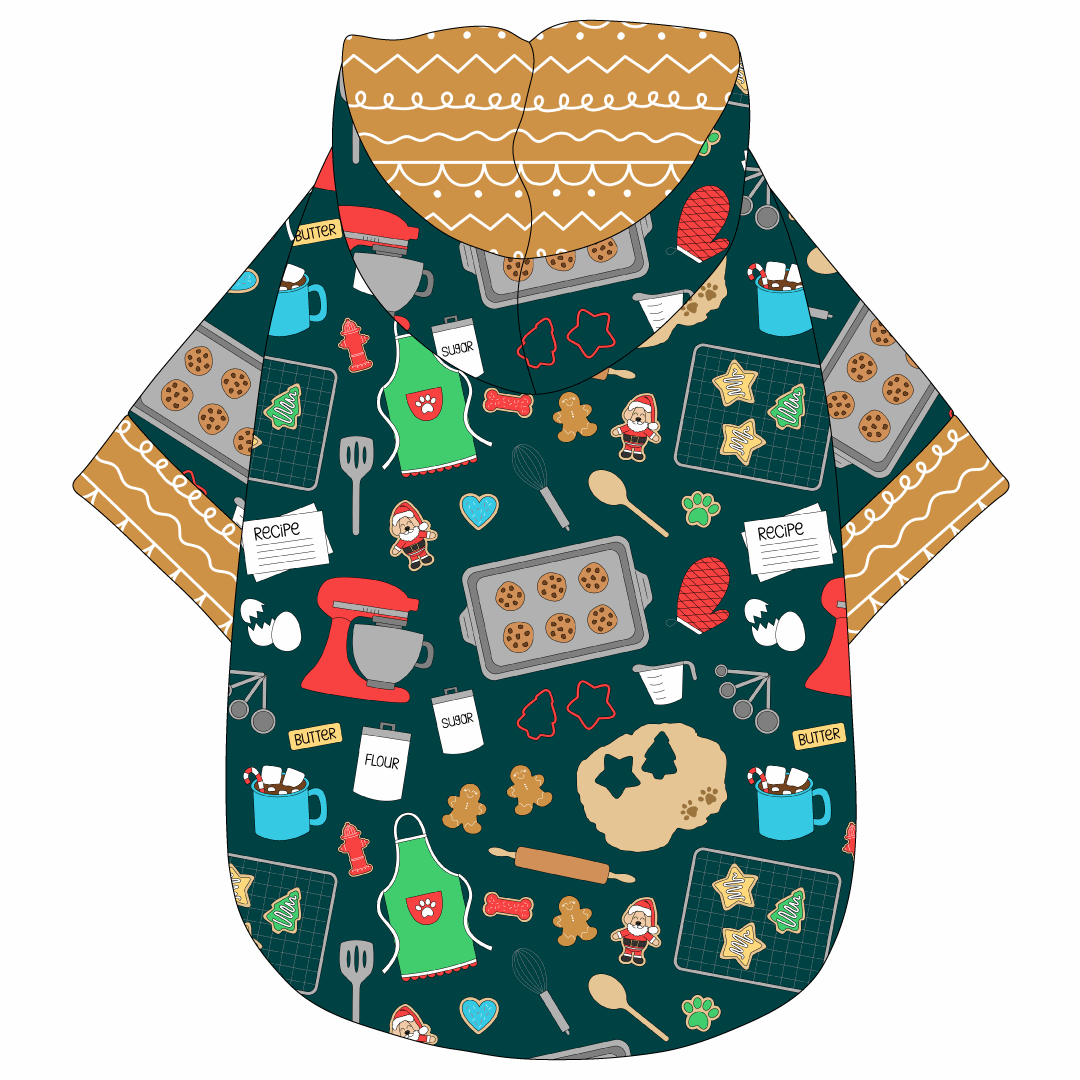 Hoodie in a dog friendly pattern that shows cookies baking, a light green apron, recipe cards and more on a deep emerald background. It's complete with a hood lined in gingerbread. Gingerbread trim is on the waist and sleeves.