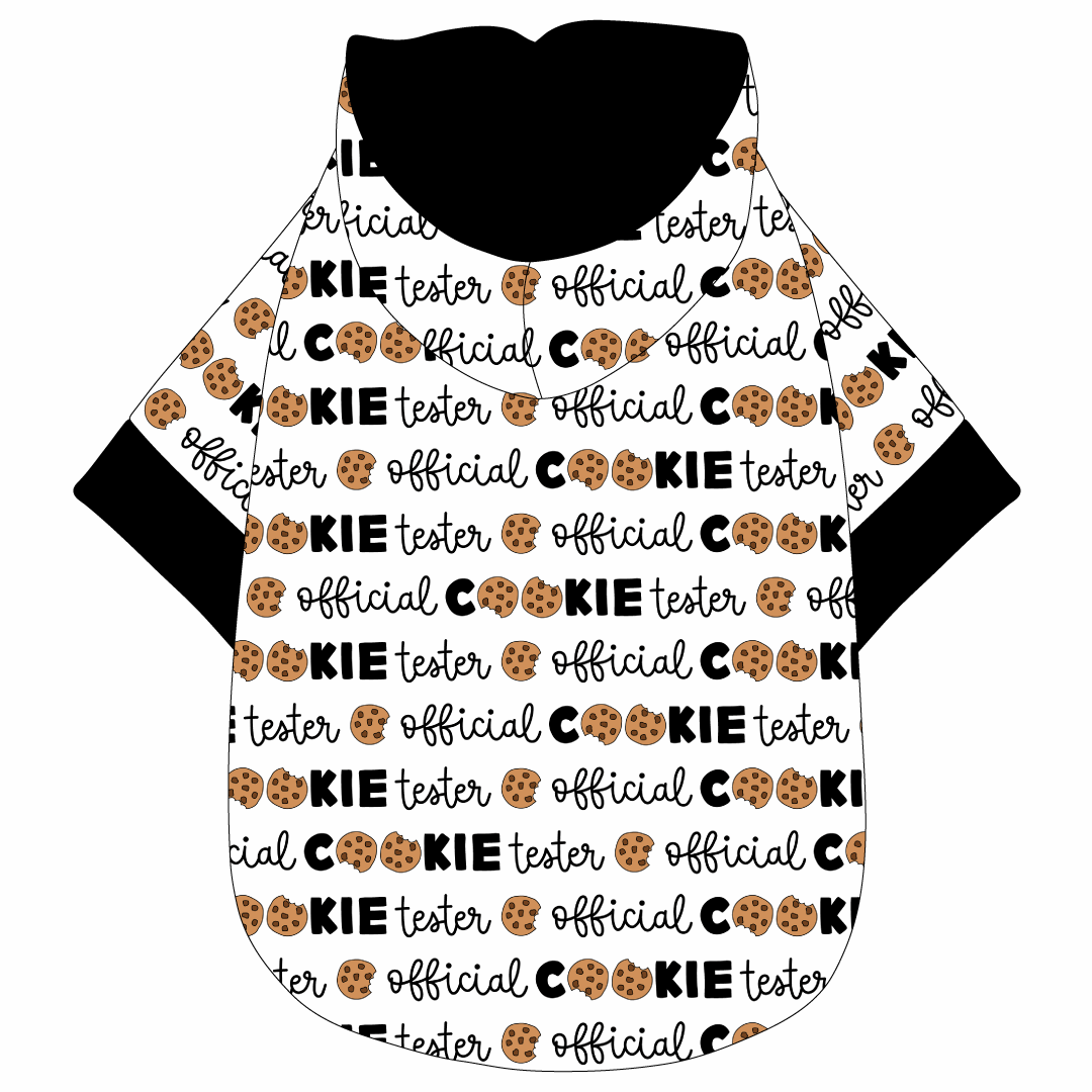 Hoodie in a dog friendly pattern that shows the text Official Cookie Tester, using two cookies for letter “o” in cookies, on a white background. It's complete with a hood lined in solid black. Black trim is on the waist and sleeves.