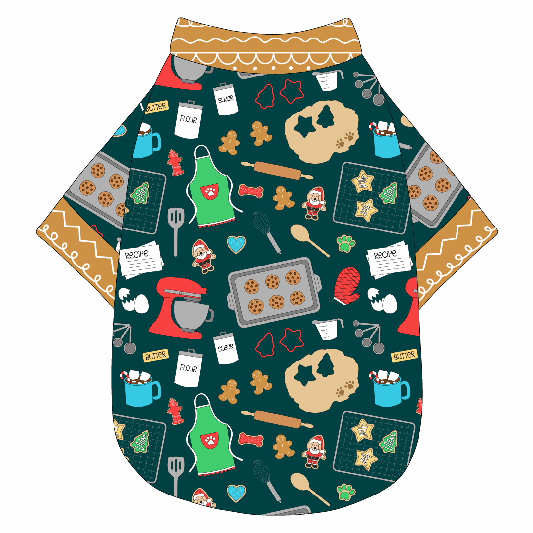 Tee shirt in a dog friendly pattern that shows cookies baking, a light green apron, recipe cards and more on a deep emerald background. It's complete with gingerbread trim on the neck, waist and sleeves.