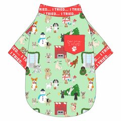 Tee shirt in a dog friendly pattern that shows the different dog breeds being naughty at Christmas.  Some are getting in gifts, some knocked over the tree, some are tangled in lights, and more. Design is on a light green background. It's complete with red trim that reads I Tried in white on the neck, waist and sleeves, as well as a red pocket that reads Dear Santa, I Tried in child's writing signed with a paw print.