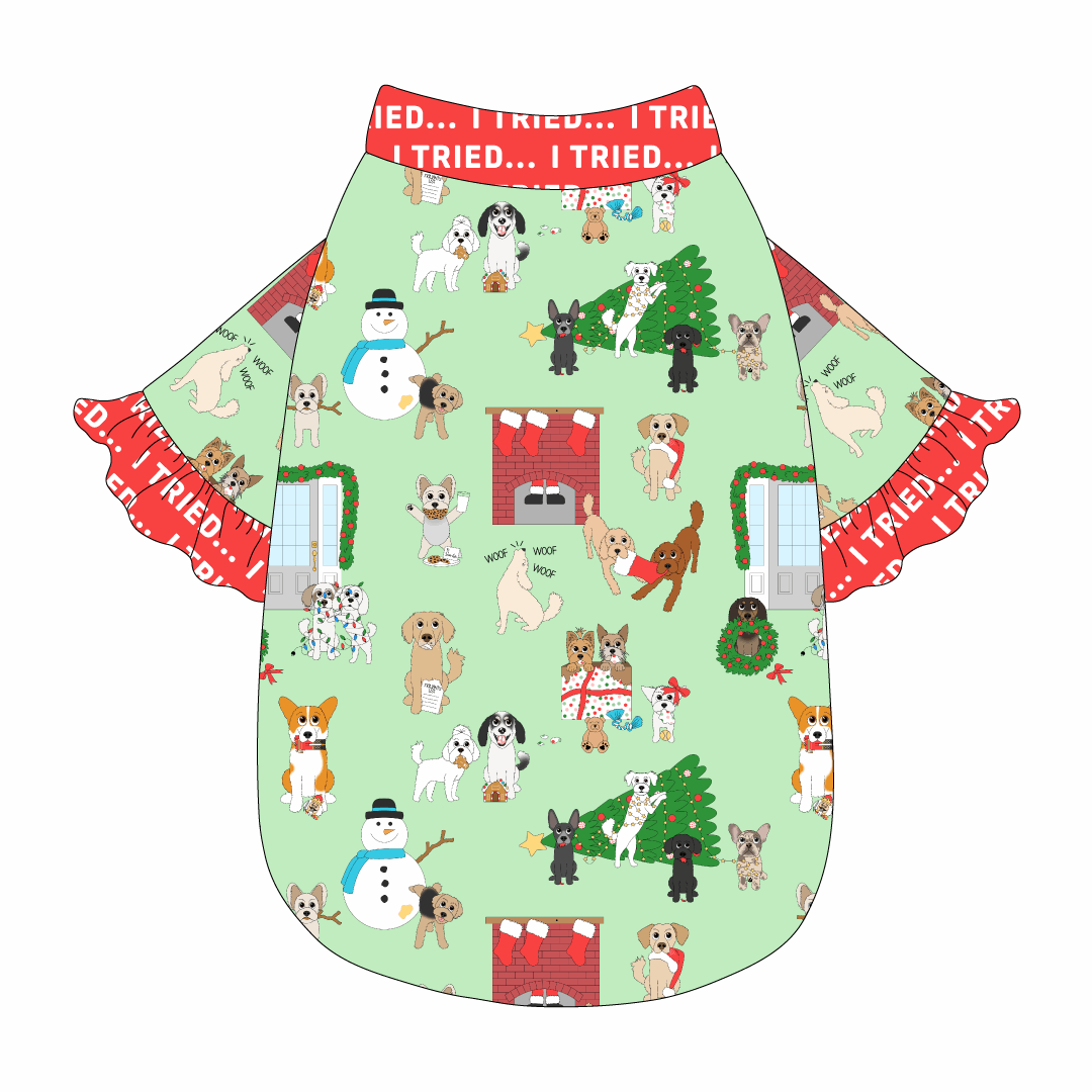 Tee style in a dog friendly pattern that shows the different dog breeds being naughty at Christmas.  Some are getting in gifts, some knocked over the tree, some are tangled in lights, and more. Design is on a light green background. It's complete with red ruffles that read I Tried on the sleeve edges. Red I Tried trim is also on the neck and waist.