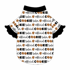 Tee style in a dog friendly pattern that shows the text Official Cookie Tester, using two cookies for letter “o” in cookies, on a white background. It's complete with black ruffles on the sleeve edges. Black trim is also on the neck and waist.