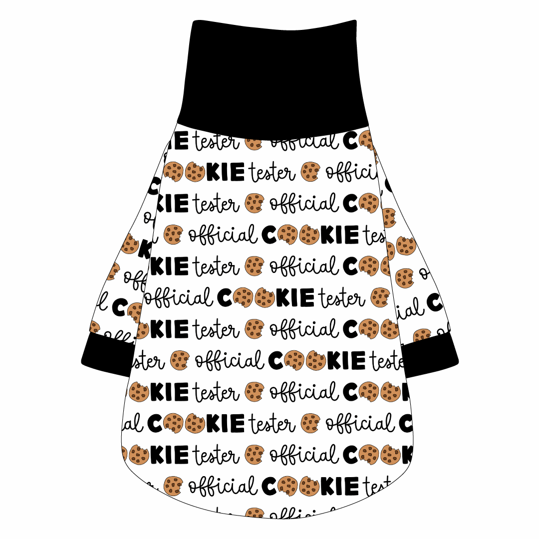 Tee shirt with turtleneck in a dog friendly pattern that shows the text Official Cookie Tester, using two cookies for letter “o” in cookies, on a white background. It's complete with black trim on the neck, waist and sleeves.