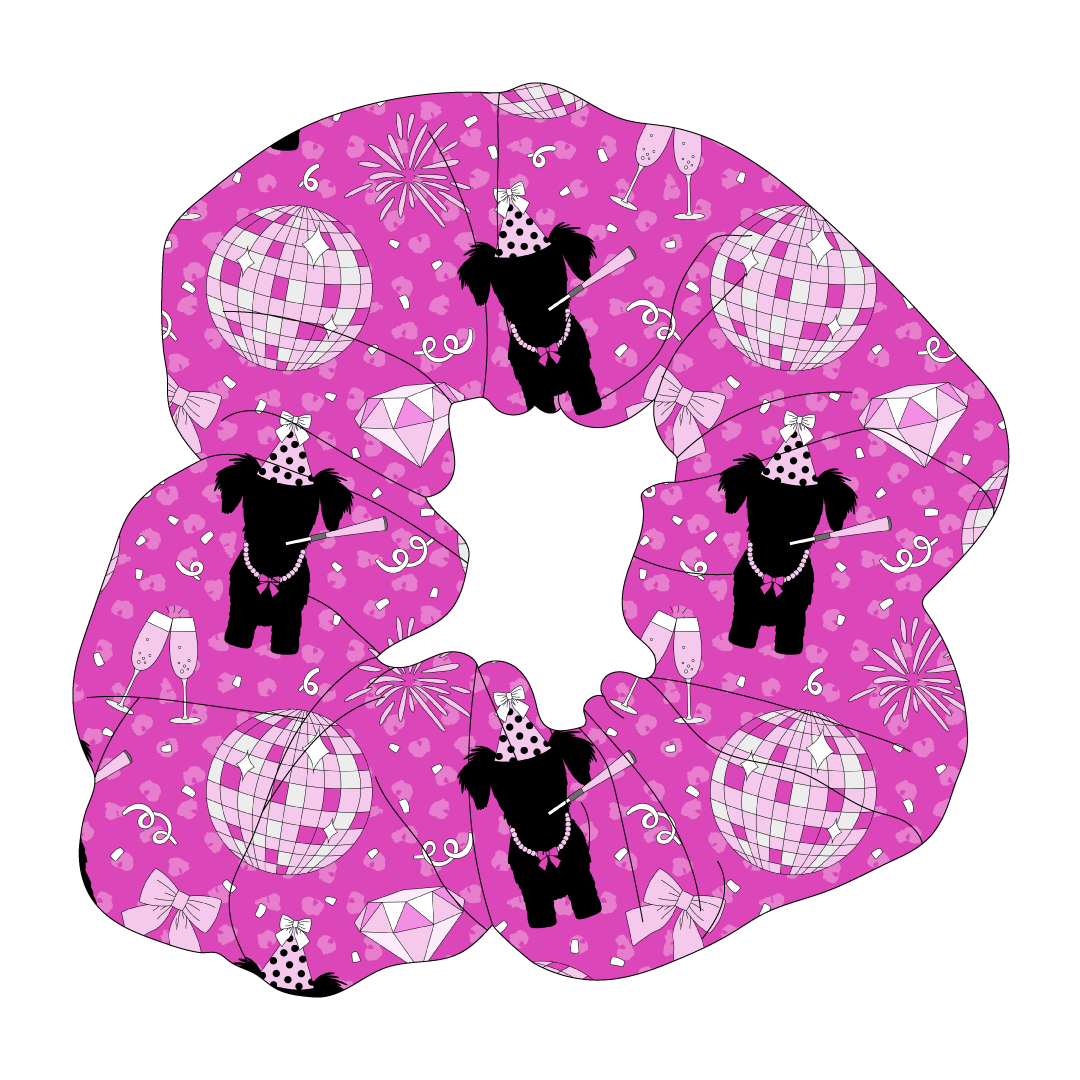 Scrunchie hair accessory in a dog friendly pattern that shows a girl dog with hat and necklace, along with a mirror ball, champagne glasses, fireworks and confetti on a magenta cheetah print background.