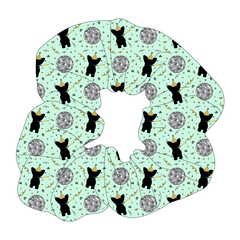 Scrunchie hair accessory in a dog friendly pattern that shows a mirror ball, dog with a party blower and confetti on a light green background.