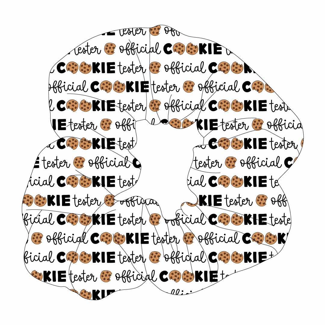 Scrunchie hair accessory in dog friendly pattern that shows the text Official Cookie Tester, using two cookies for letter “o” in cookies, on a white background.